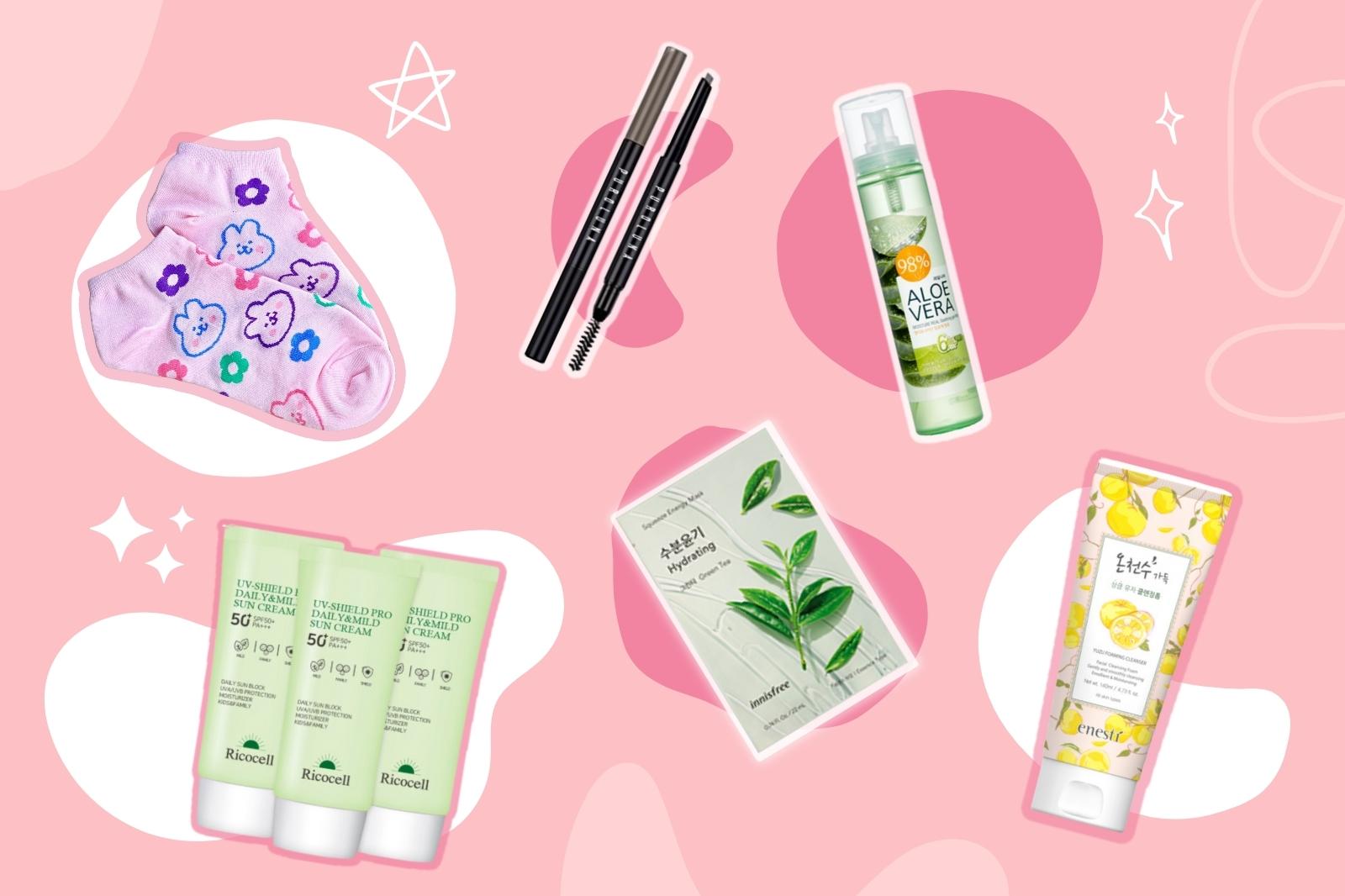 Produits de la KBeauty Box de Juin 2022 comprenant des soins de beauté pour l'été sur fond rose.