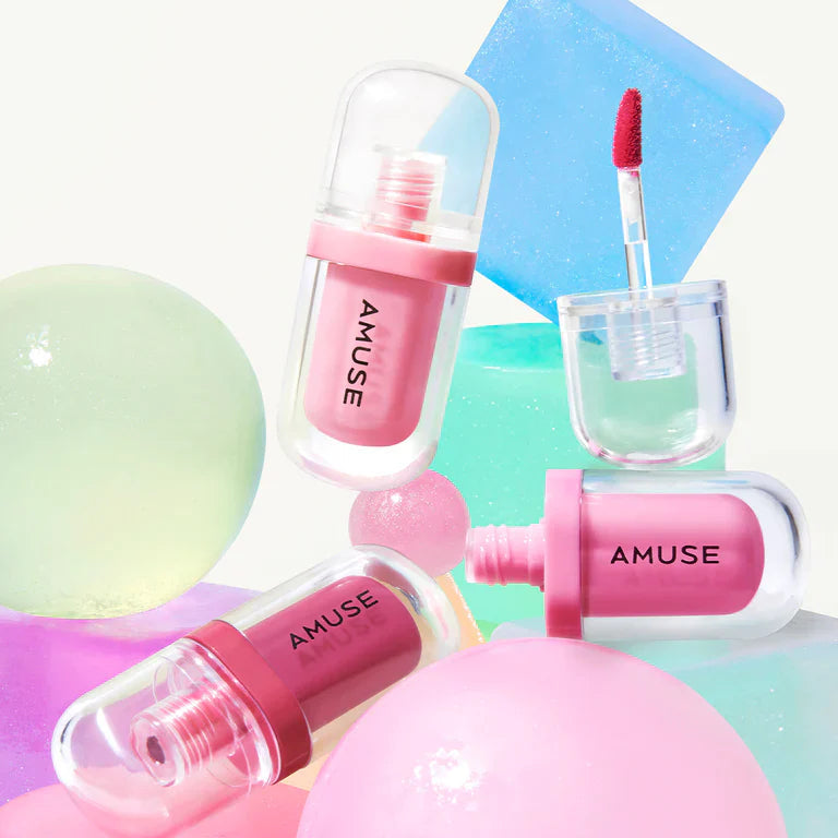 AMUSE Jel-Fit Tint de la marque AMUSE, maquillage liquide rose, applicateur et packaging sur fond pastel coloré.