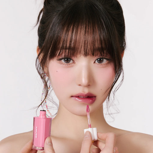 AMUSE Dew Tint de la marque AMUSE, sur fond clair, maquillage rosé en gros plan avec applicateur sur visage