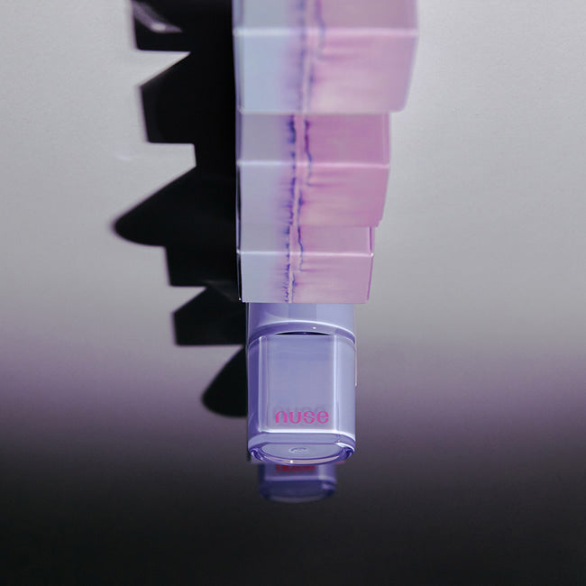 NUSE Care Liptual de NUSE, tube violet en gros plan sur fond sombre, contexte visuel industriel