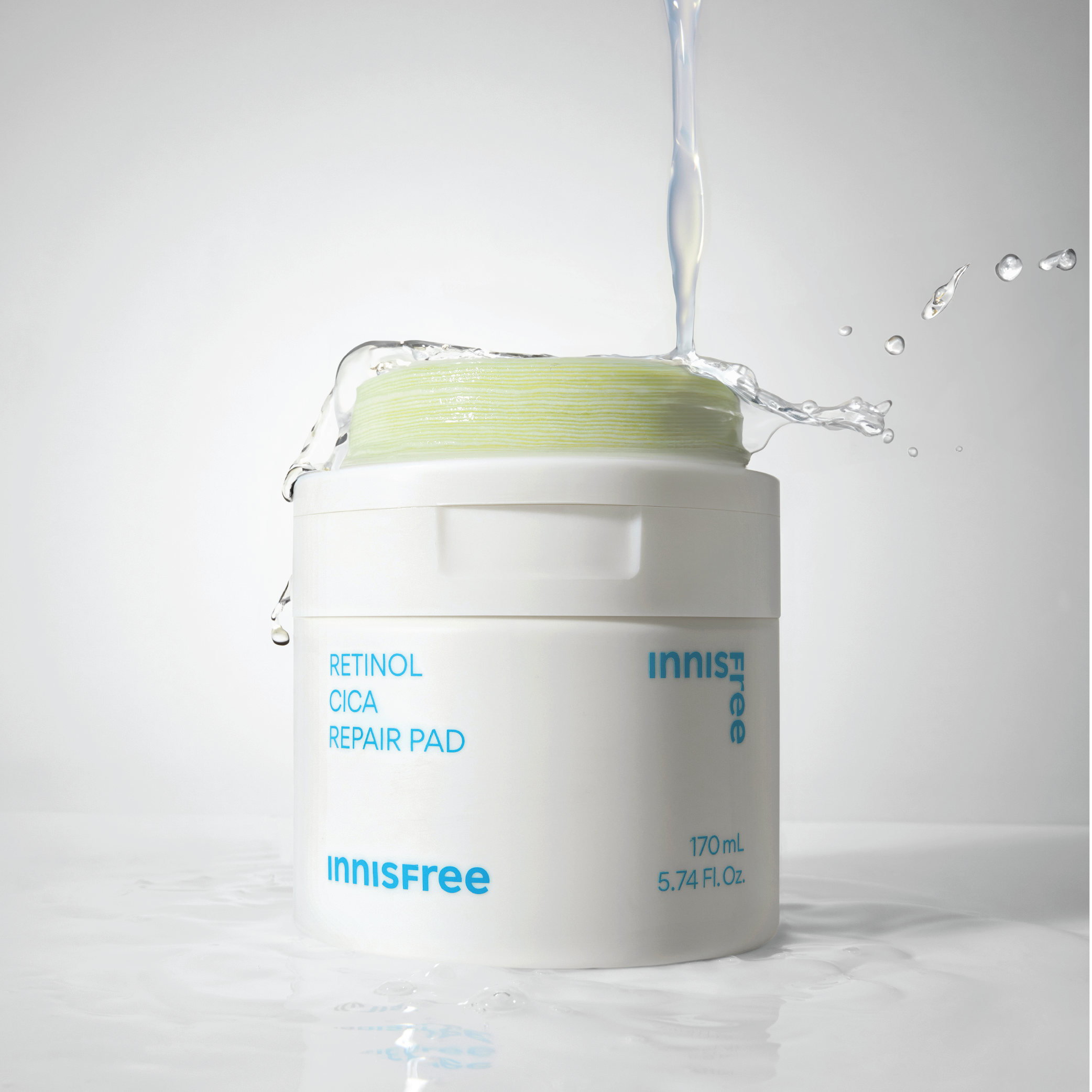 INNISFREE Retinol Cica Repair Pad 60p 170ml : pot blanc avec texte, éclaboussures d’eau, fond studio, beauté skincare
