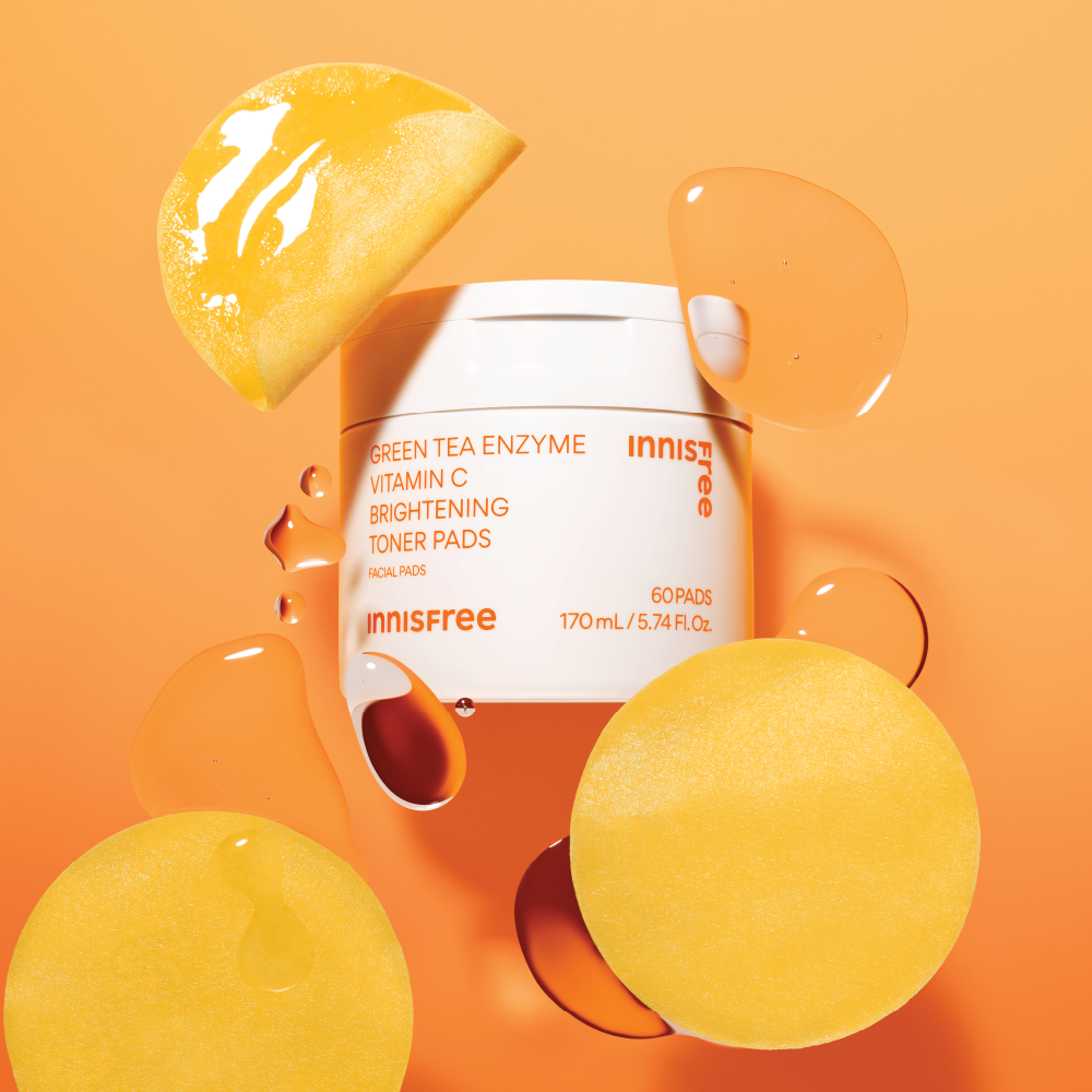 INNISFREE Vitamin C Green Tea Enzyme Brightening Pad 60p 170ml : boîte et disques sur fond orange, marque INNISFREE.