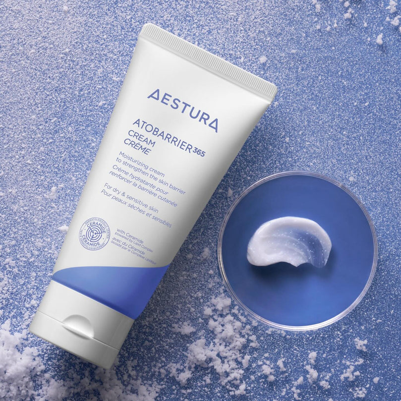 AESTURA Atobarrier 365 Cream 80ml, tube crème Aestura sur fond bleu, texture en cuillère, contexte beauté soin.