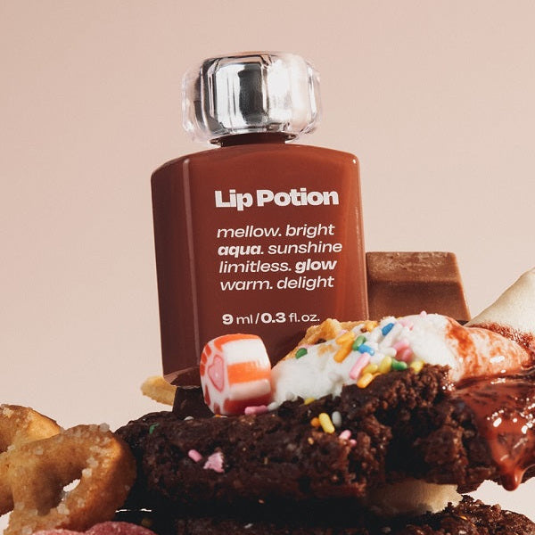 ALTERNATIVE STEREO Lip Potion Aqua Glow Tint marque Alternative, flacon sur cupcakes, contexte photo beauté.