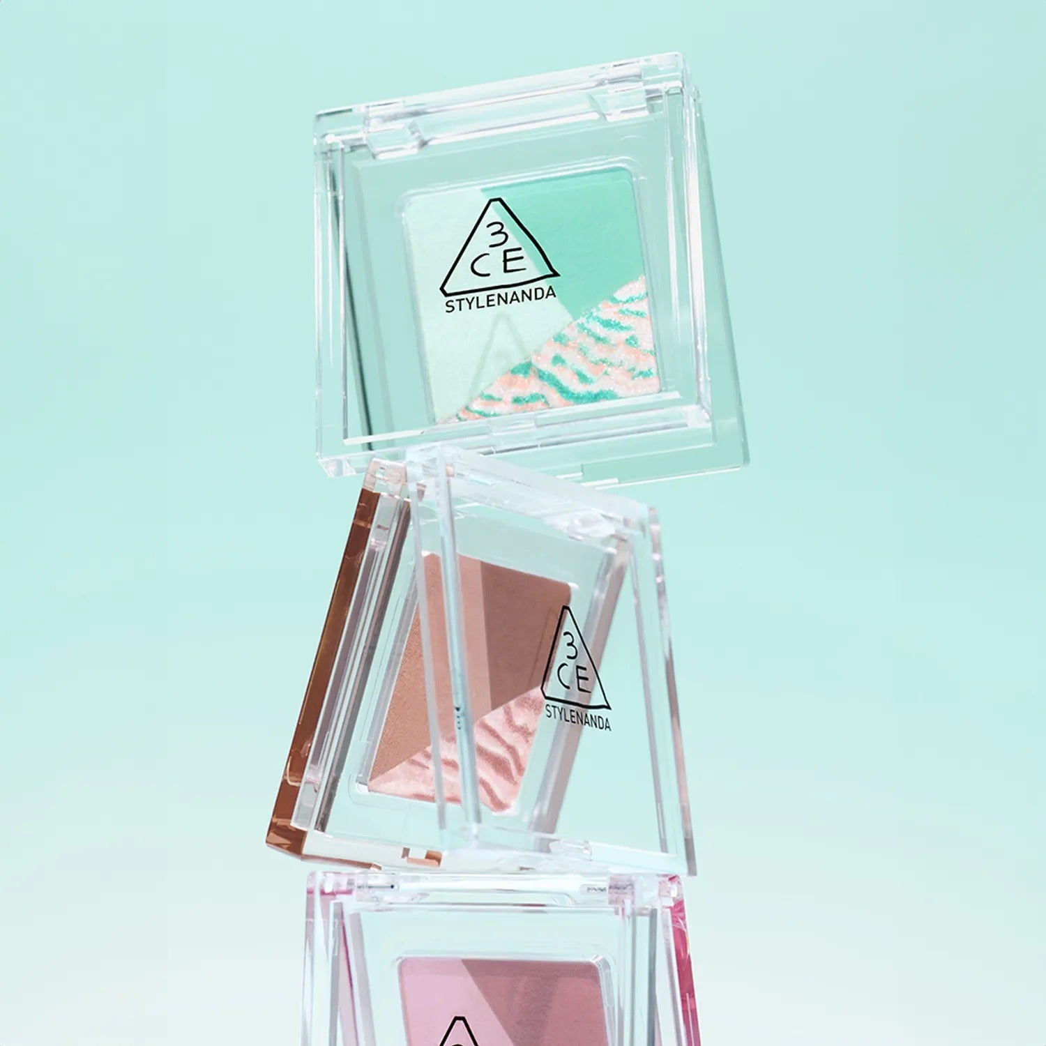 3CE Color Grid Eyeshadow, boîte transparente avec palette de fards colorés 3CE sur fond bleu clair