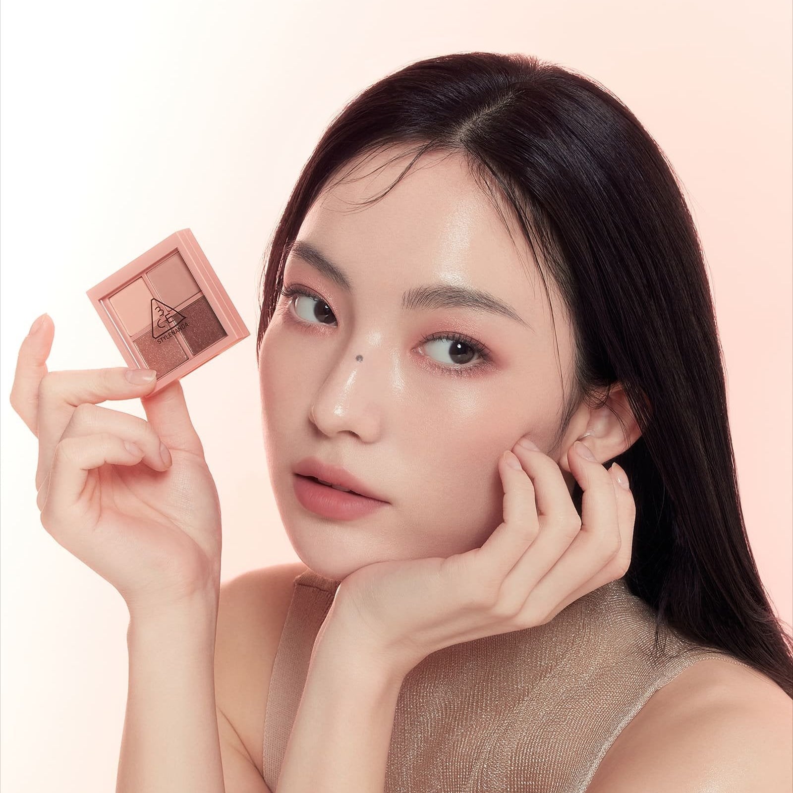 3CE Mini Multi Eye Color Palette de la marque 3CE, présentée par une femme, maquillage des yeux sur fond beige.