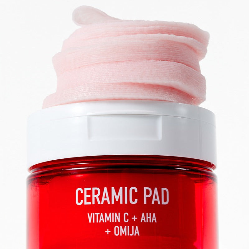 PARNELL AHA Omija Ceramic Pad 60 Pads, photo du pot sur fond blanc, coussin rose “CERAMIC PAD” vitamine C+AHA