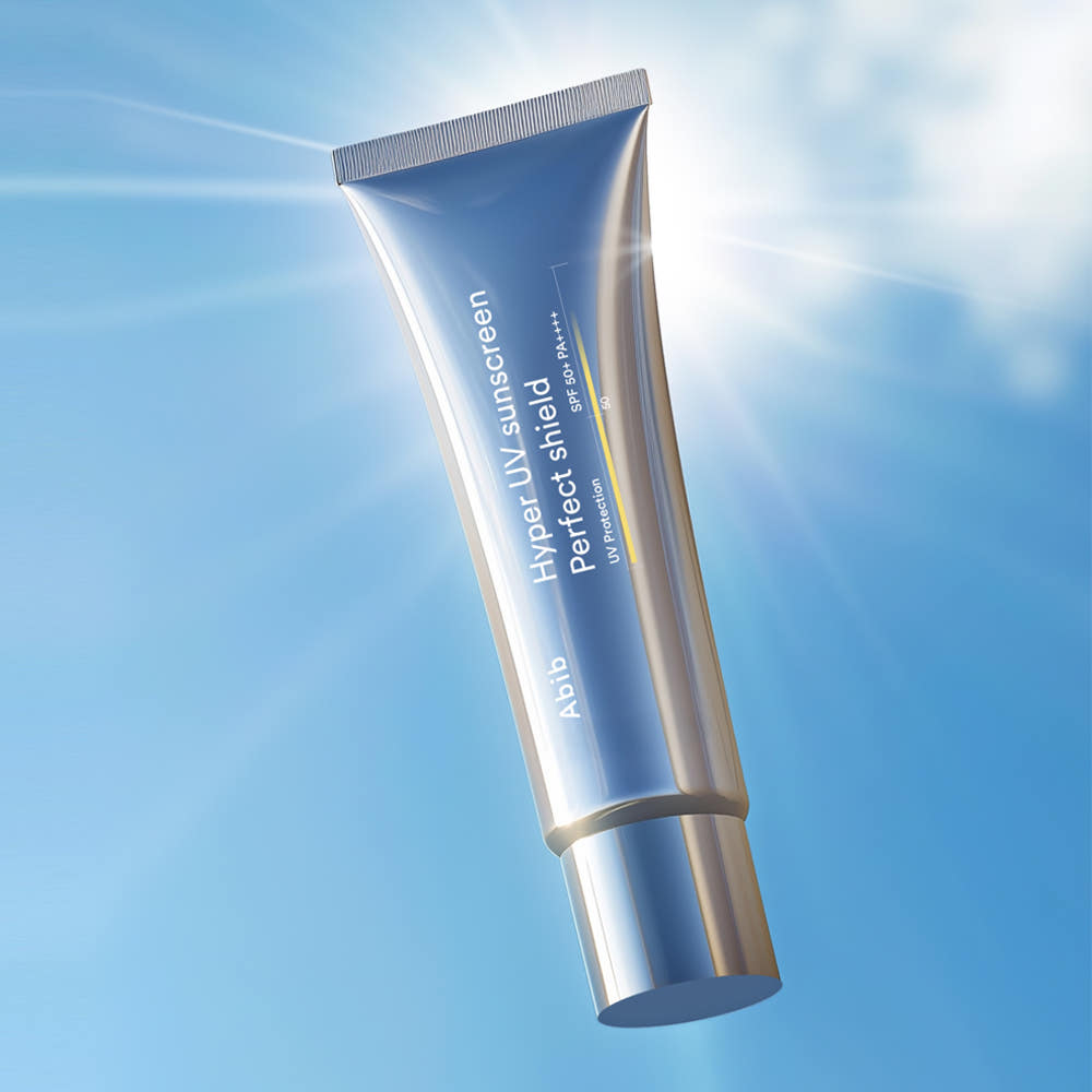 ABIB Hyper UV Sunscreen Perfect Shield 50ml, tube sur fond bleu ciel, effet solaire, marque ABIB en gros plan