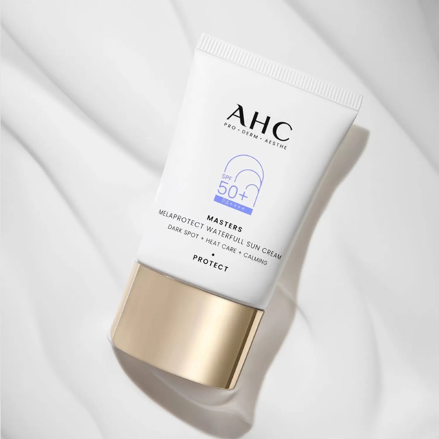 AHC Masters Mela Protect Waterfull Sunscreen 40ml d’AHC, tube SPF50+ sur tissu clair, contexte beauté minimaliste.