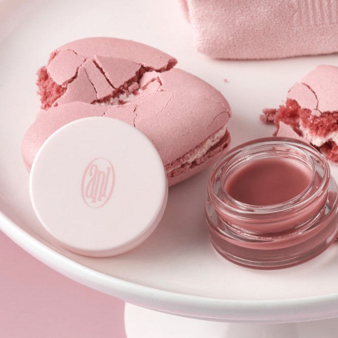 ANILLO Rose Glow Balm de la marque ANILLO, baume rosé en pot et capsule sur plateau rose, ambiance beauté