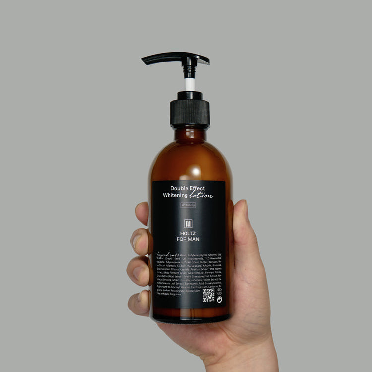 Main tenant ANNA HOLTZ For Men Double Effect Whitening Emulsion 300ml, flacon ambré avec pompe, fond uni.