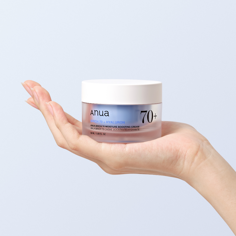 Main présentant ANUA Birch 70 + Hyaluron Moisture Boosting Cream 50ml, crème hydratante Anua sur fond clair.