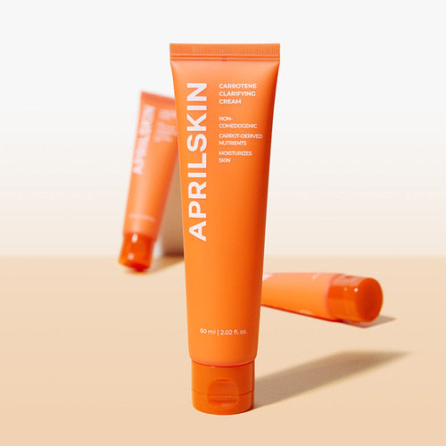 Décris l'image en français : APRILSKIN Carrotene Clearifying Cream 60ml d’APRILSKIN, tube orange sur fond clair.