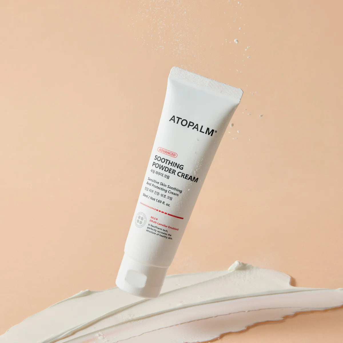 Décris l'image en français : ATOPALM Soothing Powder Cream 50ml, tube blanc sur fond beige, texture crème apaisante.