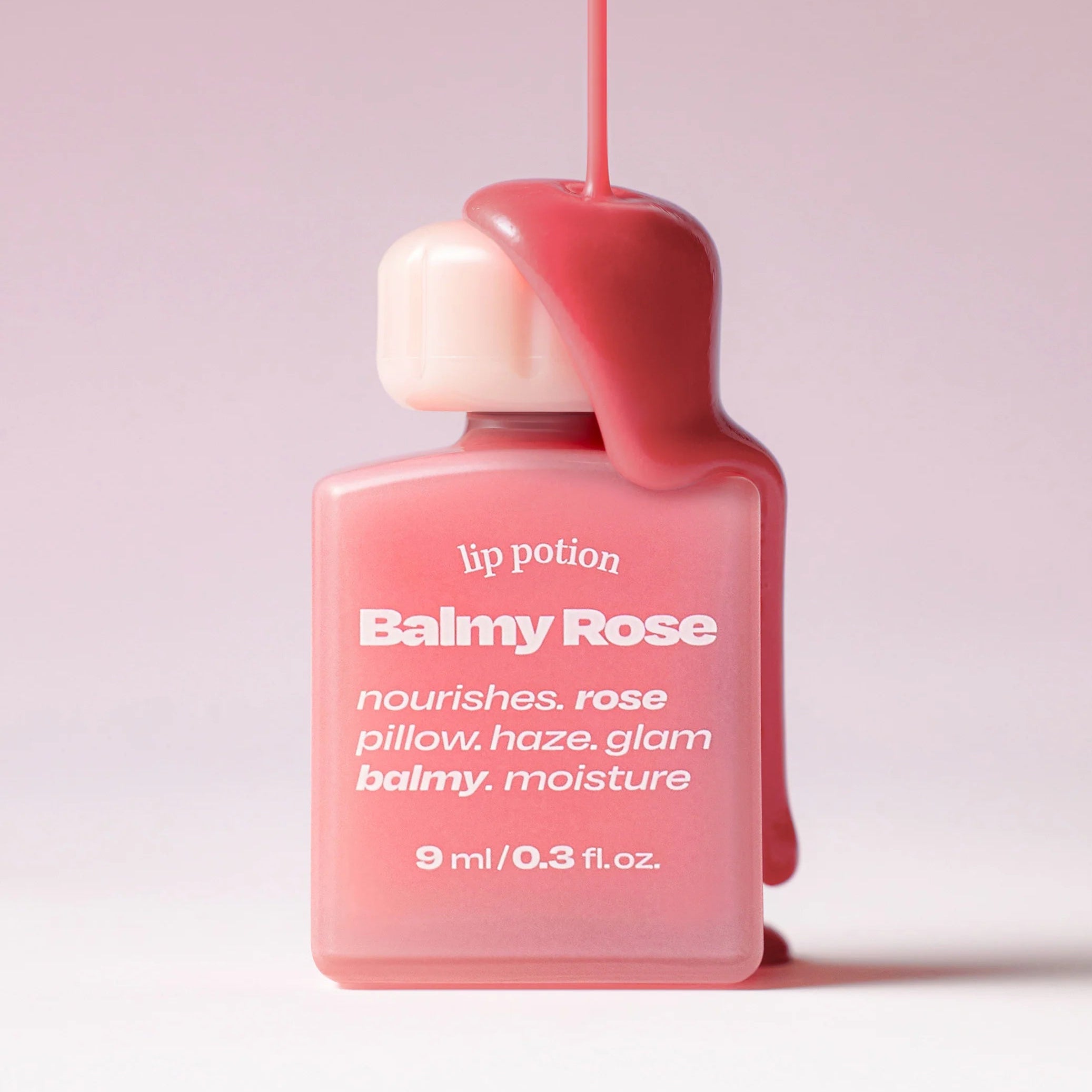 ALTERNATIVE STEREO Lip Potion Balmy Rose de la marque Alternative Stereo, flacon rouge sur fond rose, gros plan.
