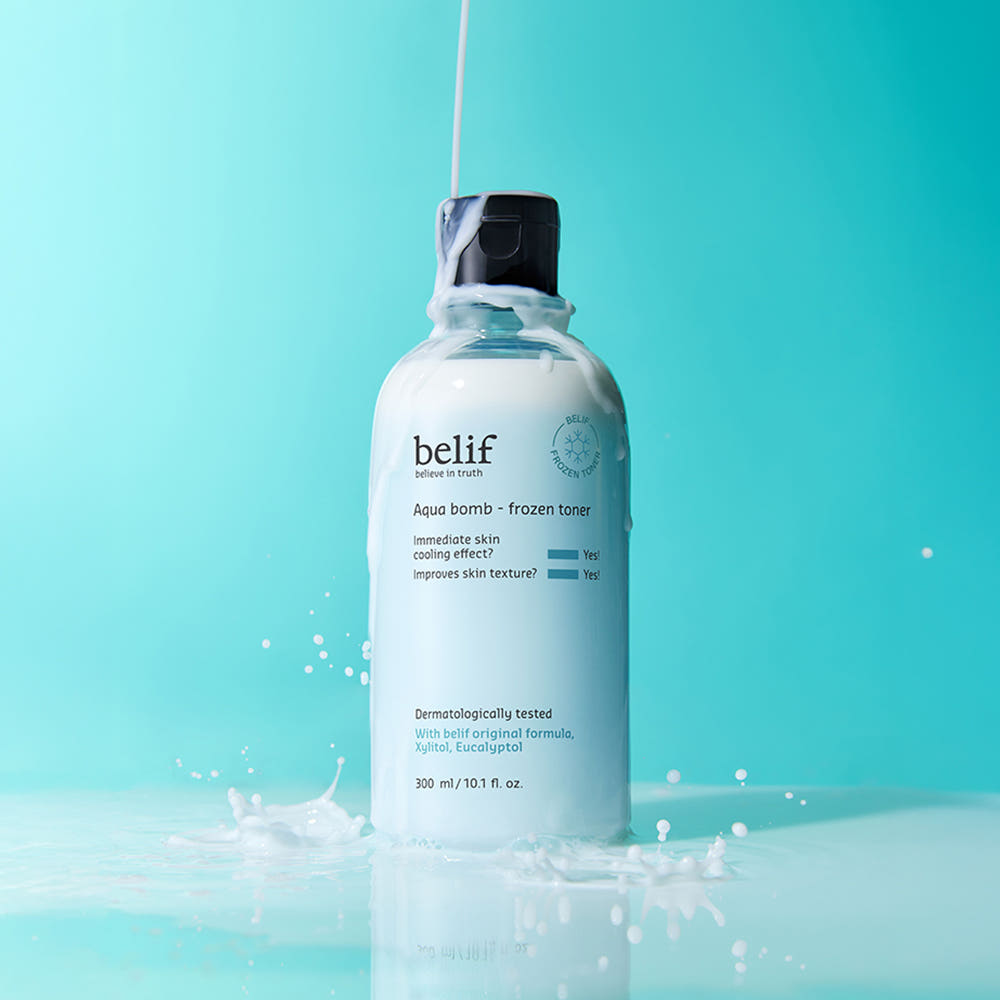 BELIF Aqua Bomb Frozen Toner 330ml, flacon BELIF sur fond bleu, éclaboussures et gouttes d’eau glacée.