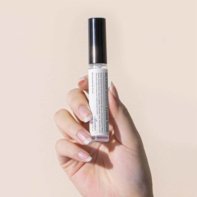 Main tenant BENTON Honest Eyelash Serum 10ml, flacon sur fond clair, photo produit de la marque Benton