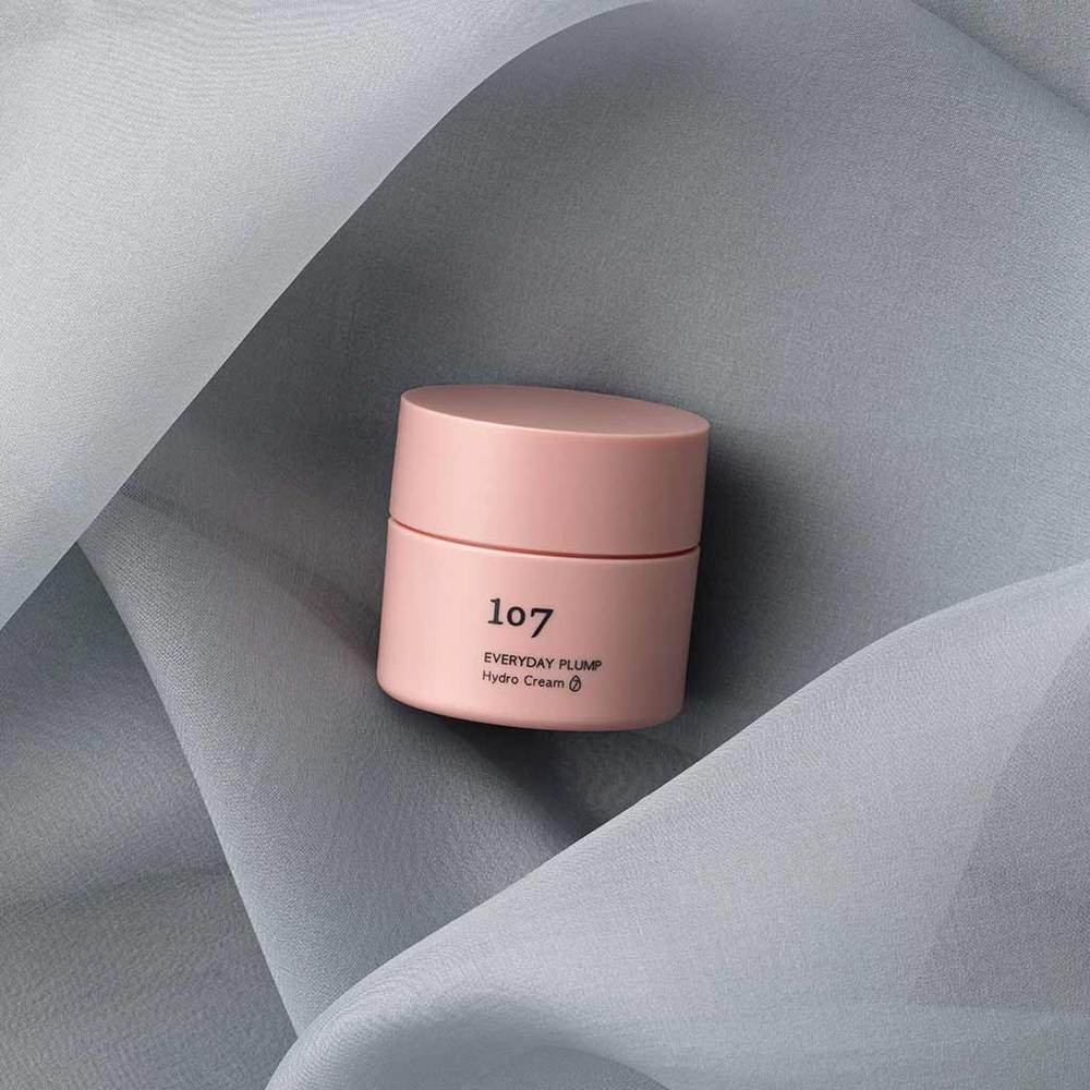 107 Everyday plump Hydro Cream 50ml de la marque 107, pot crème rose sur tissu gris drapé, ambiance soin visage