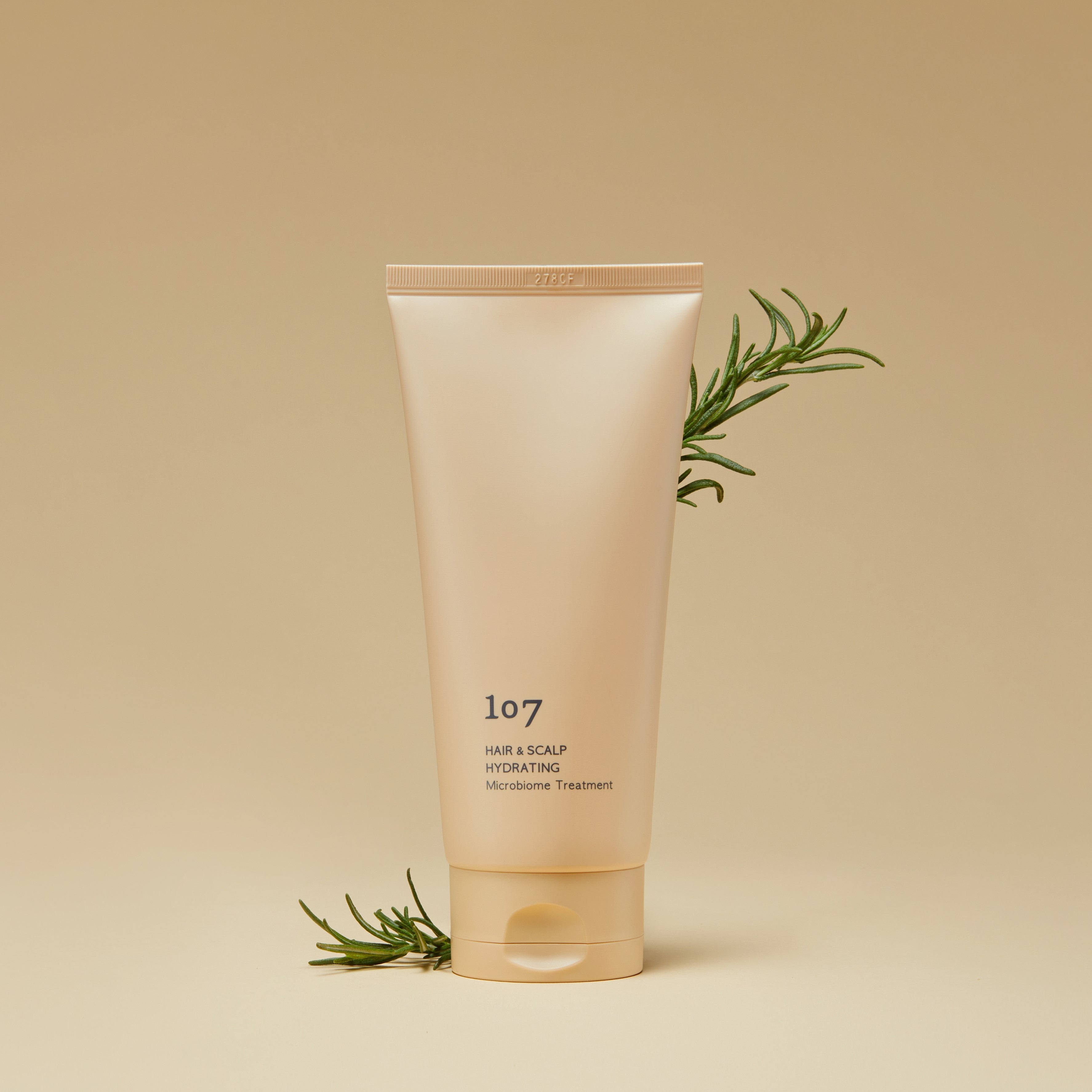 107 Hair & Scalp Hydrating Microbiome Treatment 180ml de la marque 107, tube crème sur fond beige avec herbes