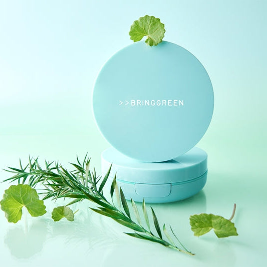 BRINGGREEN Tea Tree Cica Tone Up Sun Cushion de la marque, flacon bleu sur fond clair avec herbes et feuilles.
