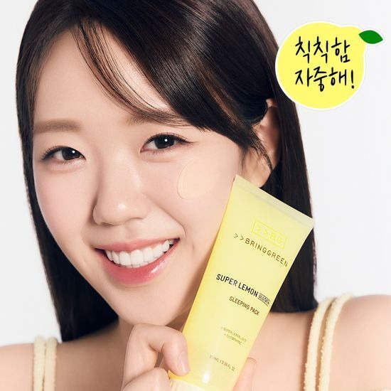 Femme souriante avec BRINGGREEN Super Lemon Glutathione Sleeping Pack 100mL à la main, accent sur la peau lumineuse et fraîche.