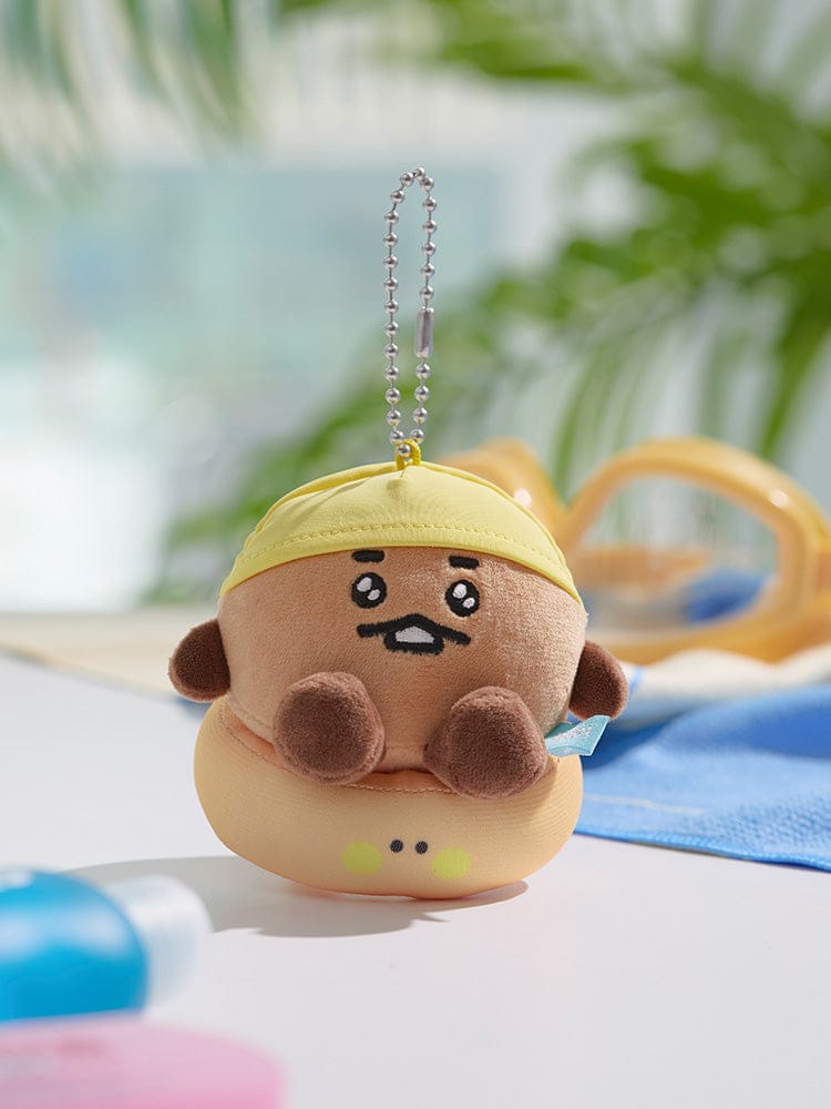 BT21 BABY PLUSH KEYRING SPLASH EDITION, porte-clés en peluche BT21 près d’un tapis bleu, fan K-pop, extérieur flou.