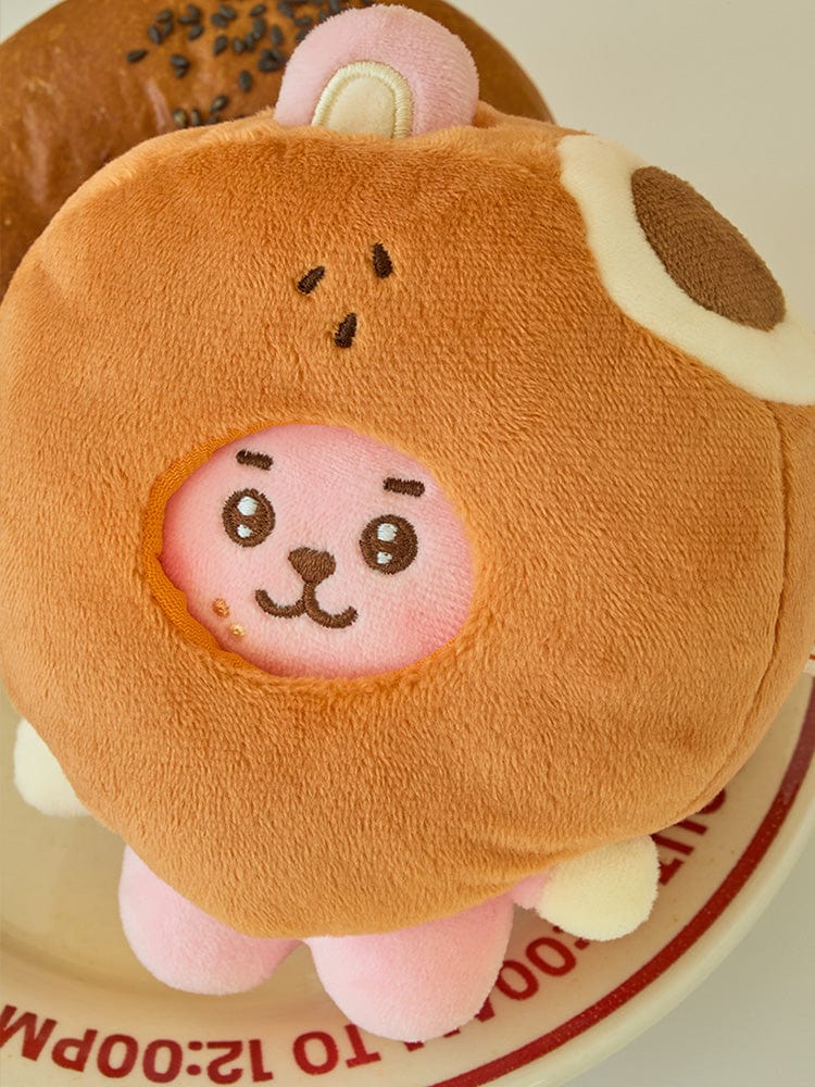 BT21 COOKY BABY COSTUME PLUSH DOLL BAKERY SHOP, peluche bébé COOKY en costume boulanger, sur présentoir.