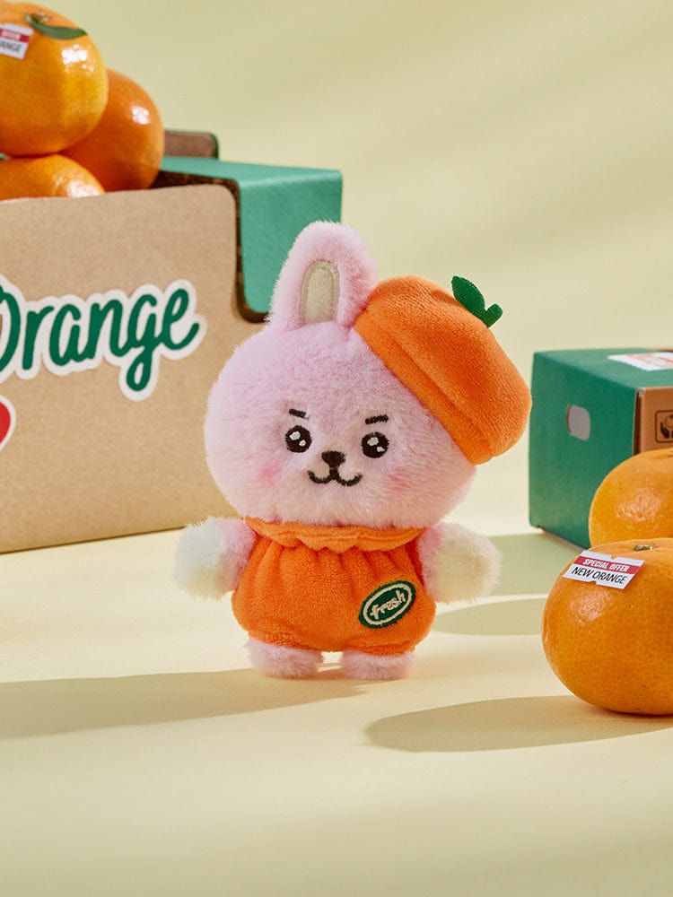 BT21 COOKY BABY PLUSH ORANGE PARTY : peluche orange COOKY lapin musclé BTS, présentée sur fond vert, pack officiel LINE.