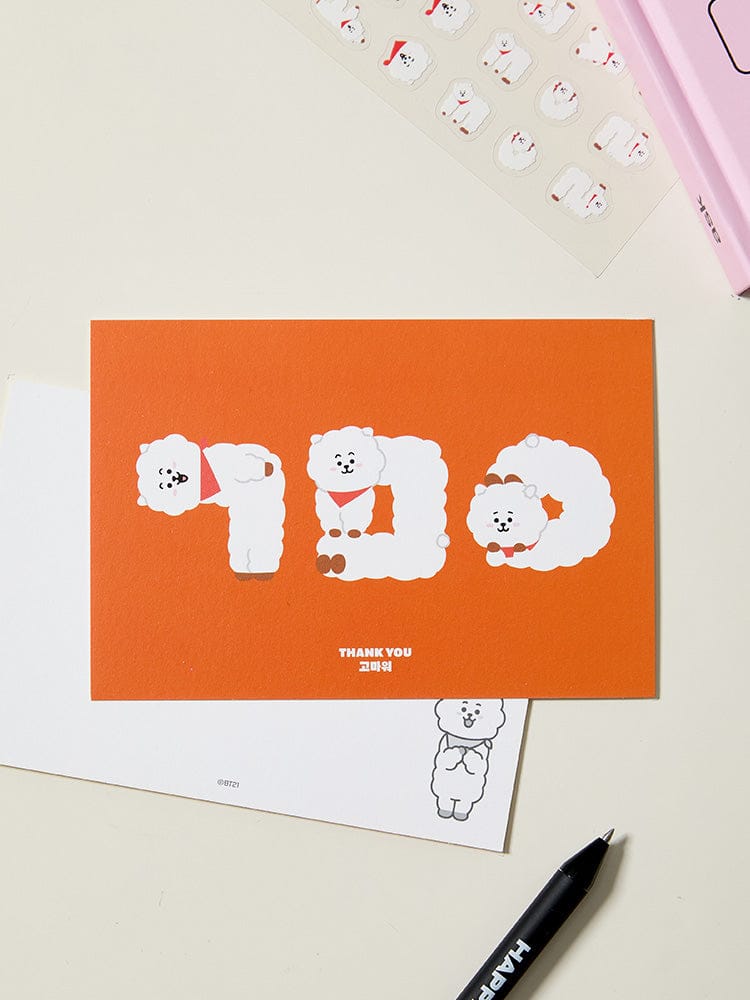 BT21 HANGEUL POSTCARD SOUVENIR : carte postale coréenne BT21 LINE FRIENDS sur bureau, personnages en visuel orange et blanc.