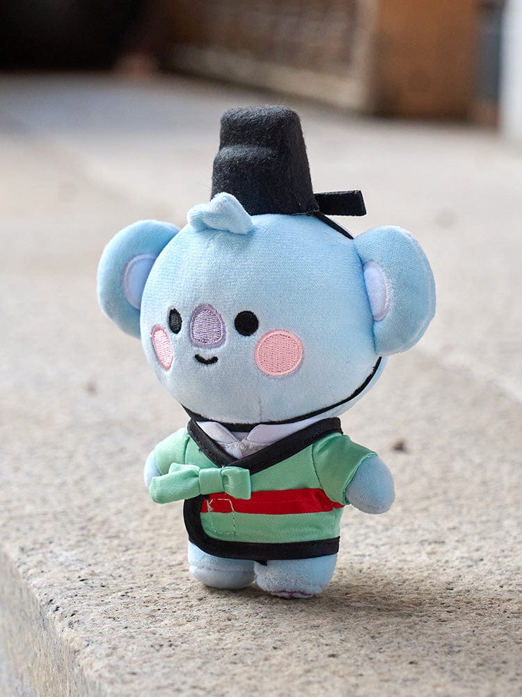 BT21 KOYA BABY PLUSH DOLL K-EDITION 2 : peluche officielle KOYA koala RM, tenue verte, sur sol, chambre