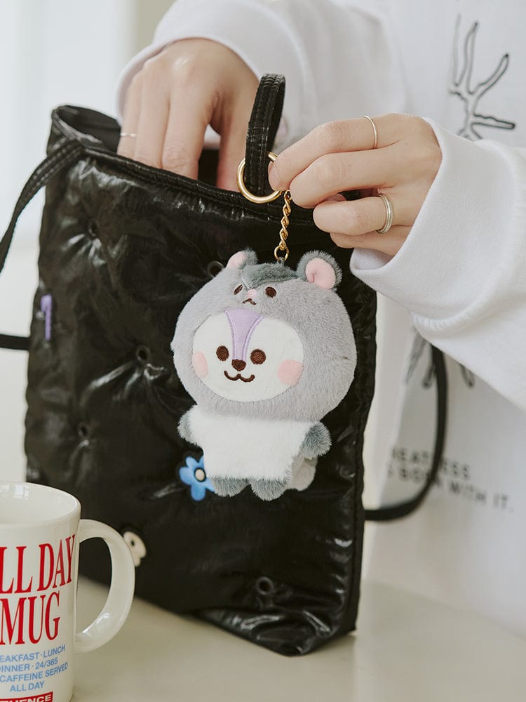 BT21 MANG BABY PLUSH KEYRING FLUFFY, porte-clés en peluche MANG LINE FRIENDS, accroché à un sac, mains tenant la chaînette.