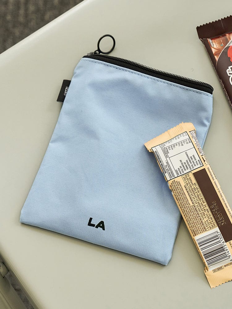 BT21 POUCH LA CITY EDITION : pochette bleu LA, personnages BT21, accessoire LINE FRIENDS BTS, design premium sur table crème.