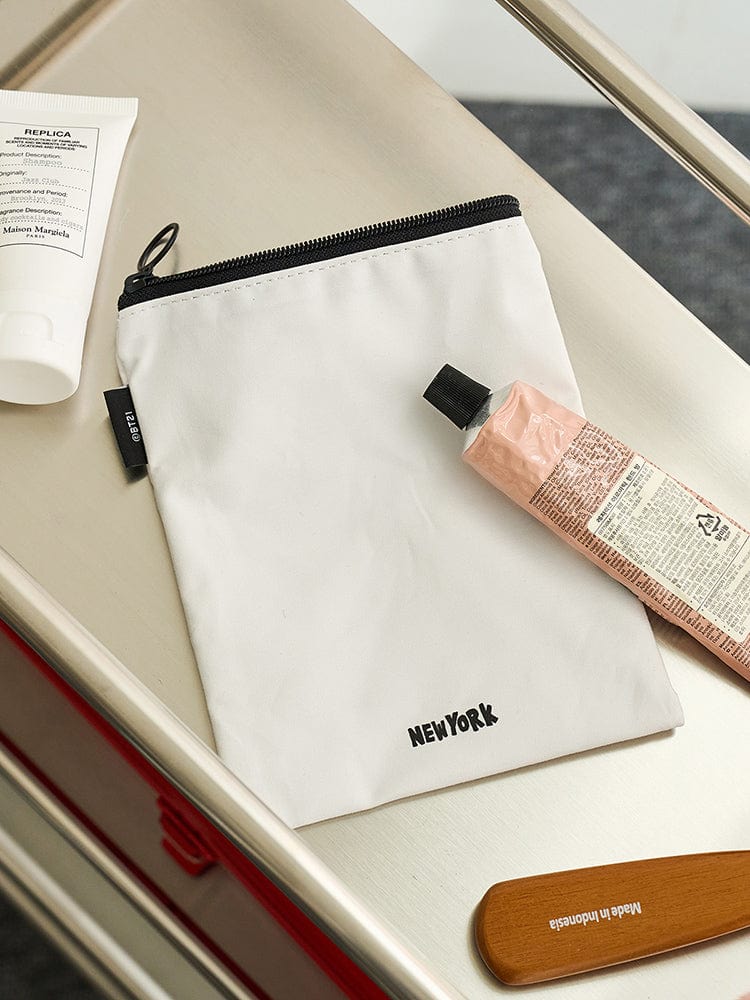 BT21 POUCH NEW YORK CITY EDITION : pochette blanche LINE FRIENDS avec zip, patch “NEW YORK”, personnages BT21 sur fond de bureau