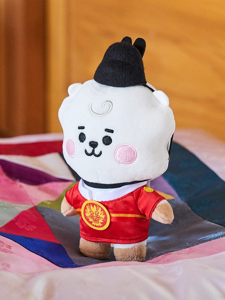 BT21 RJ BABY PLUSH DOLL K-EDITION 2 : peluche officielle LINE FRIENDS alpaga RJ, sur lit multicolore, style bébé.