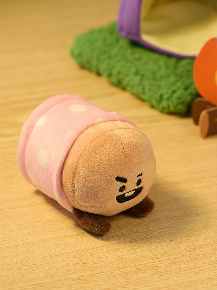 BT21 SHOOKY DOLL CAMPFIRE peluche officielle LINE FRIENDS, SHOOKY en biscuit devant un jouet sur table en bois.