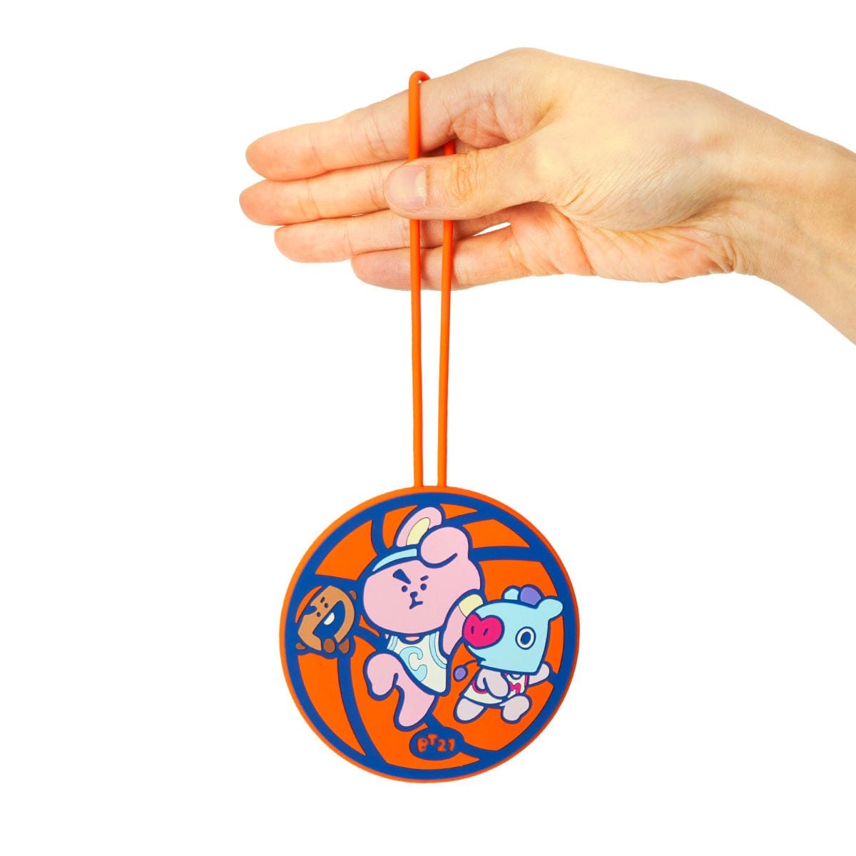 BT21 SPORTS CLUB LUGGAGE TAG BASKETBALL, main tient une étiquette voyage orange avec personnages BT21 sur fond blanc