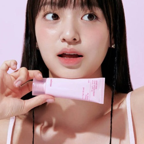 Décris l'image en français en mentionnant le produit, la marque et le contexte visuel : CELIMAX Heart Pink Tone-up Sun Cream 40ml, tube rose.