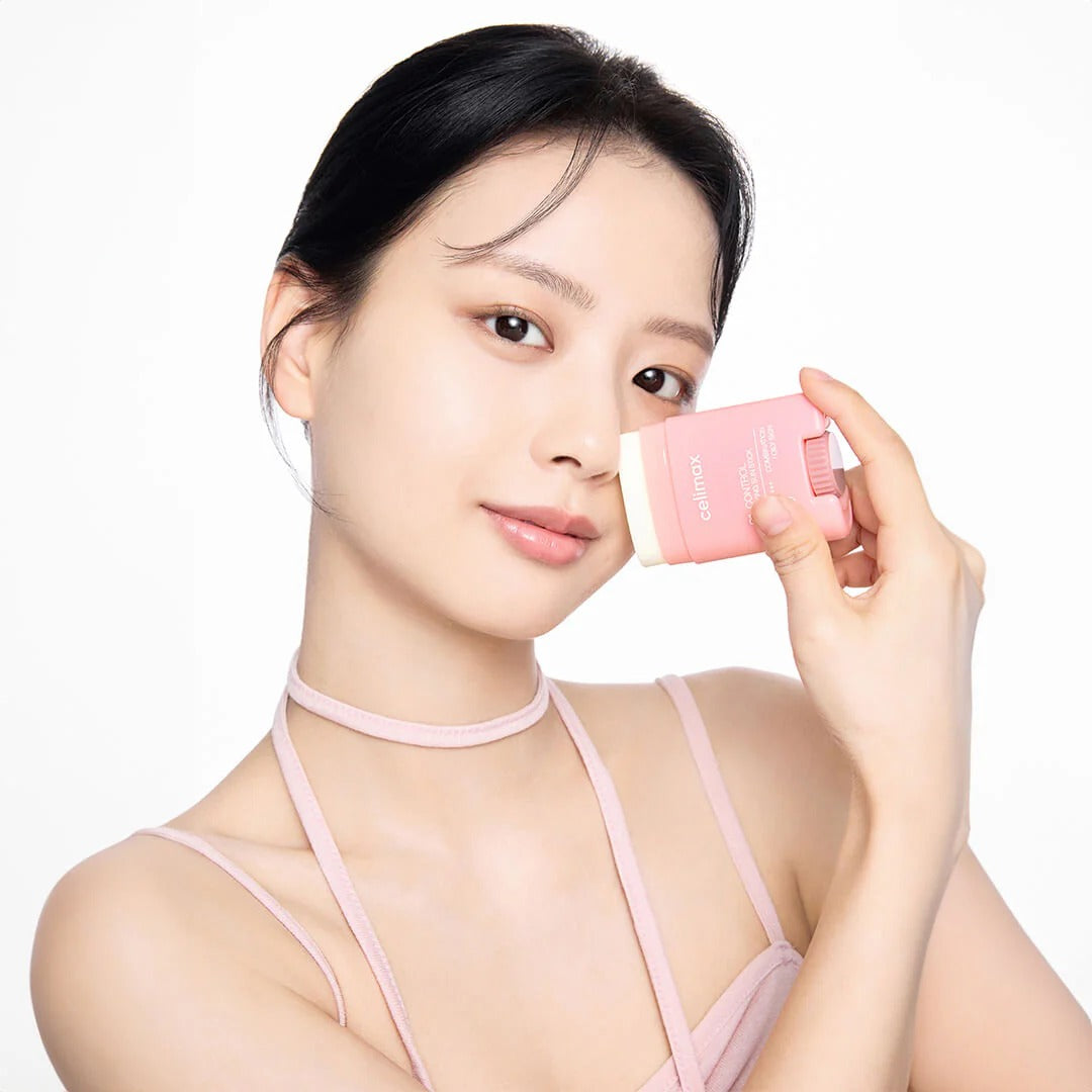 CELIMAX Oil Control Sun Stickk 19g, femme applique un stick solaire anti-brillance rose sur fond clair.