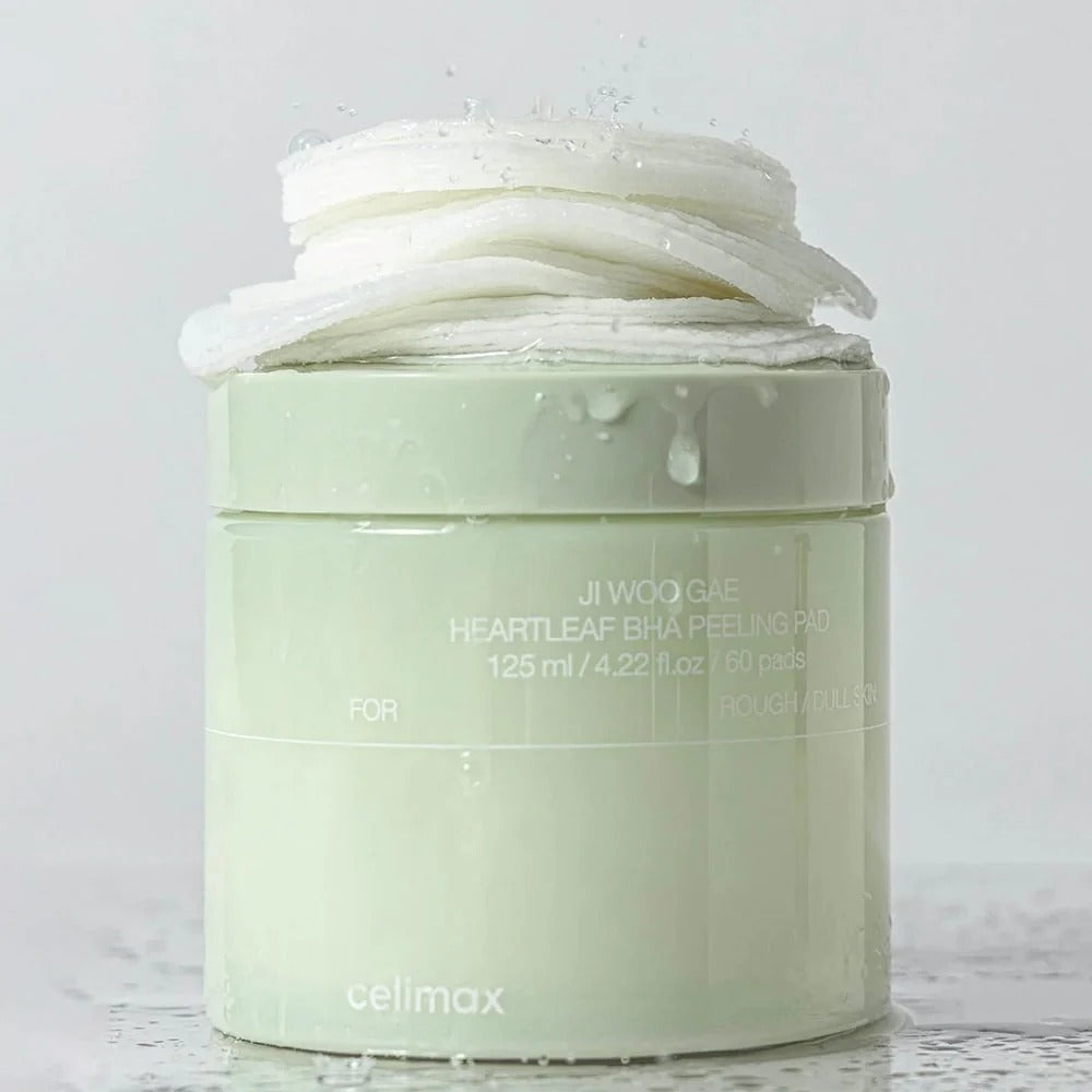 Boîte de CELIMAX Ji Woo Gae Heartleaf BHA Peeling Pad 60 Pads avec tampons exfoliants empilés en haut, 125ml, sur fond humide.