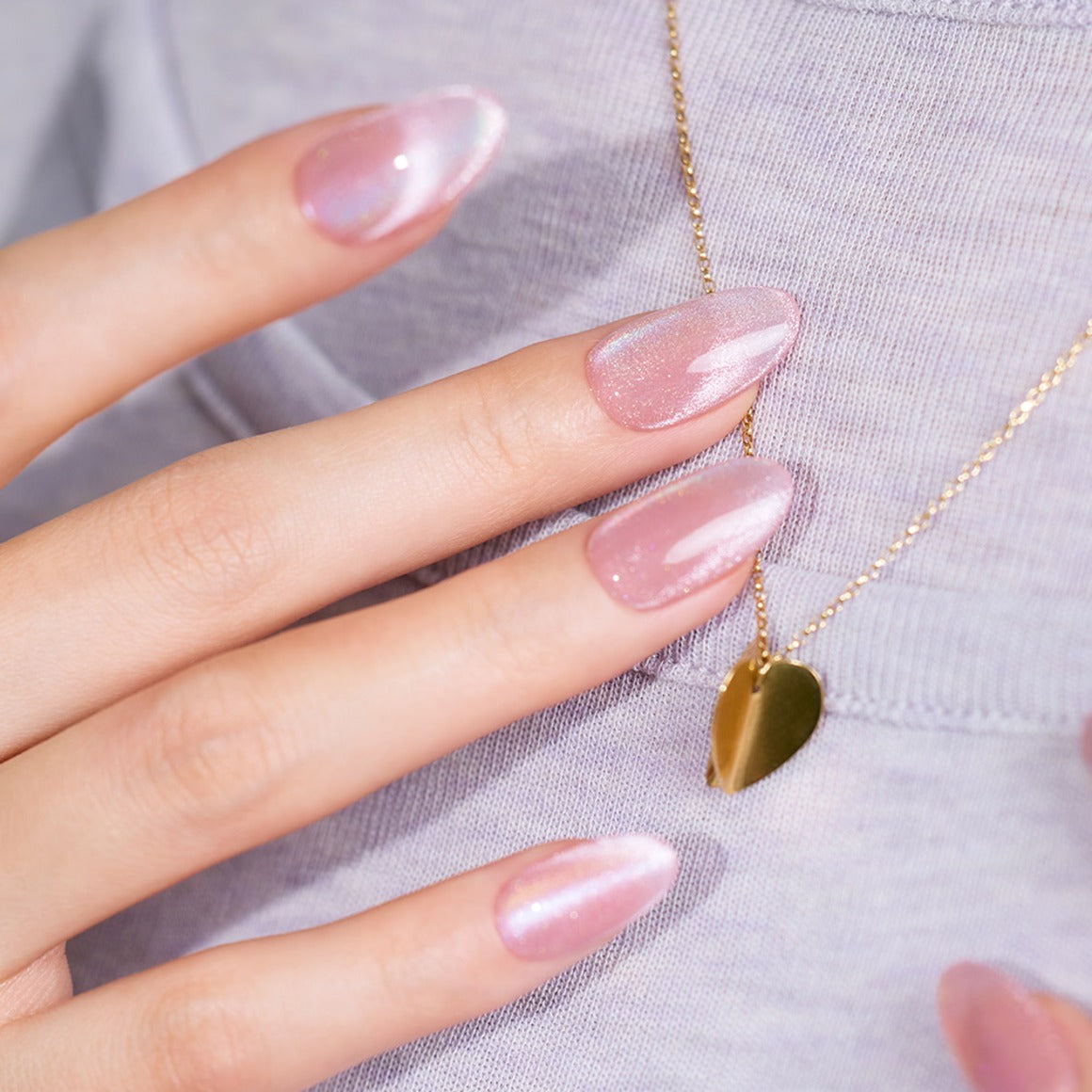 DASHING DIVA Glowberry (Almond) sur ongles avec effet brillant, sur pull gris, main et bijou, style lifestyle.