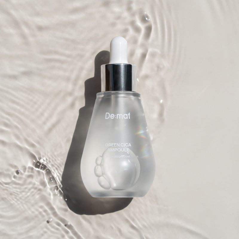 DE:MAF Green Cica Pore Ampoule 50ml, flacon De:maf sur fond clair avec éclaboussures, focus peau apaisée