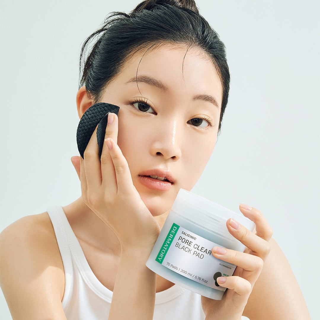 DERMATORY Salicinic Pore Clear Black Pad 70 Pads : femme applique un pad noir sur le visage, pot et packaging en gros plan.