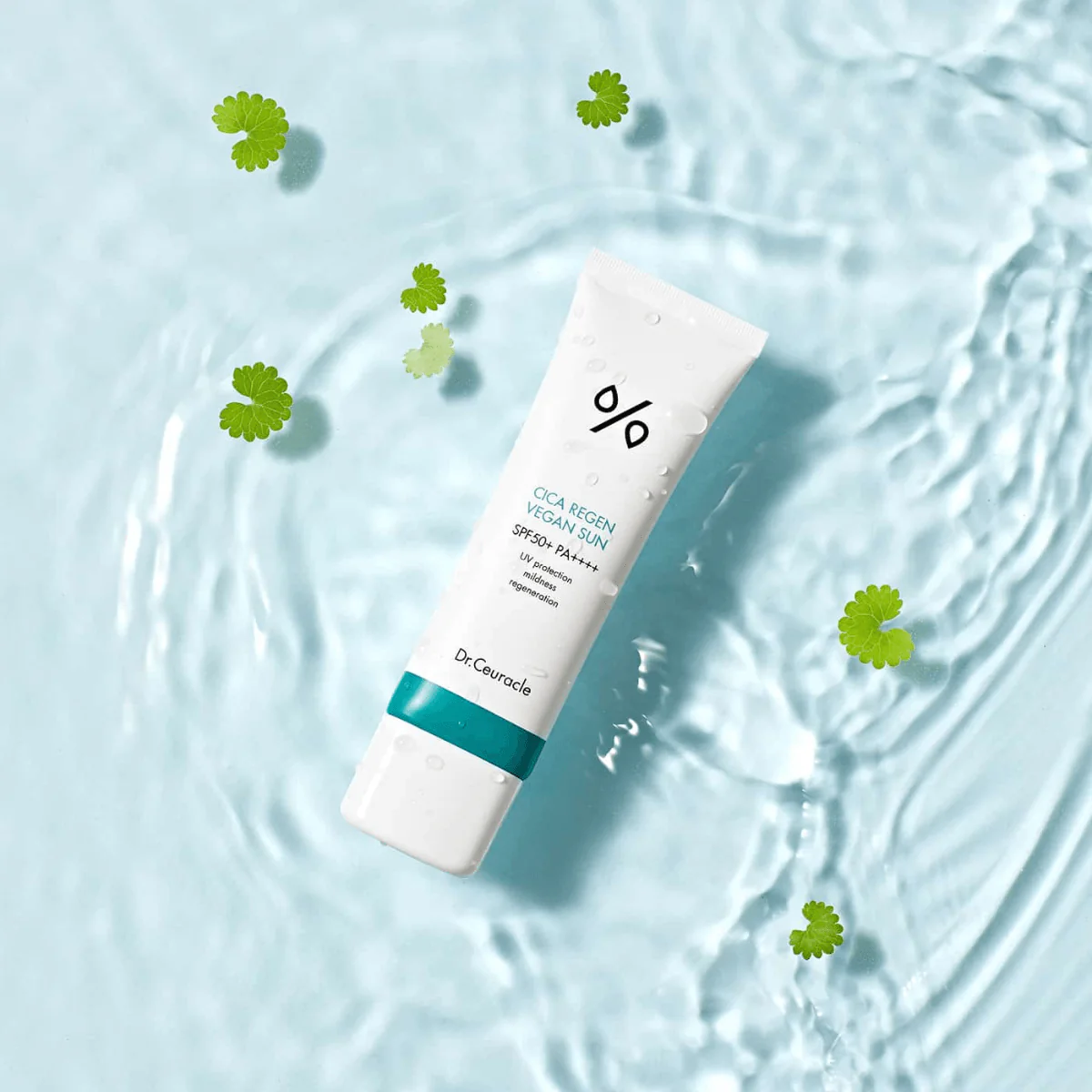 DR.CEURACLE Cica Regen Vegan Sun SPF50+PA++++ 50ml, tube sur eau claire bleue avec feuilles, marque au centre.
