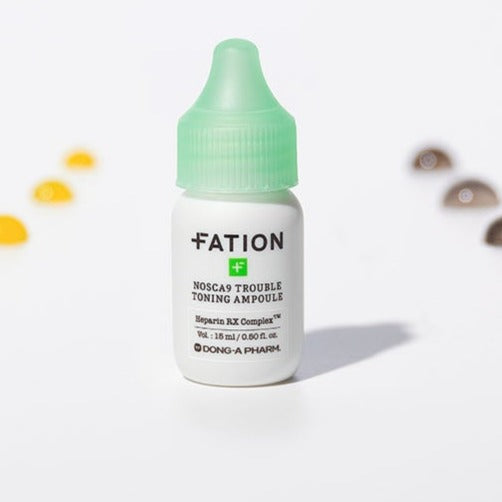 FATION Nosca9 Trouble Toning Ampoule 15ml : flacon FATION vert/blanc sur fond clair avec éléments flous, contexte beauté.