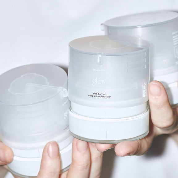 GLOW Aloe Barrier Support Cream 50ml de la marque GLOW, crème barrière à l’aloe vera, pots blancs en main, visuel propre