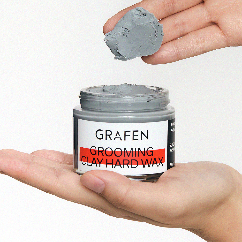 GRAFEN Grooming Clay Hard Wax 75ml : pot de cire coiffante dans la main, texture argile grise, fond clair.