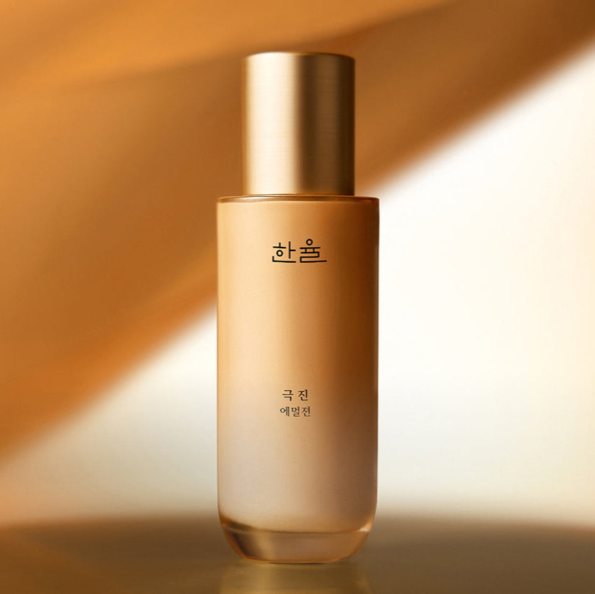 HANYUL Extreme Emulsion 125ml, flacon doré sur fond beige chaud, éclairage studio élégant.