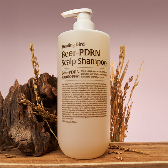 HEALING BIRD Beer PDRN Anti-Hair Loss Shampoo 1000ml, flacon blanc sur table avec épis et racines, contexte naturel.