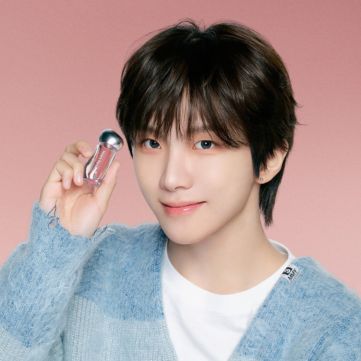 HEART PERCENT Dot On Mood Over Melting Gloss, flacon effet vitré sur fond rose, maquillage mode bouclé