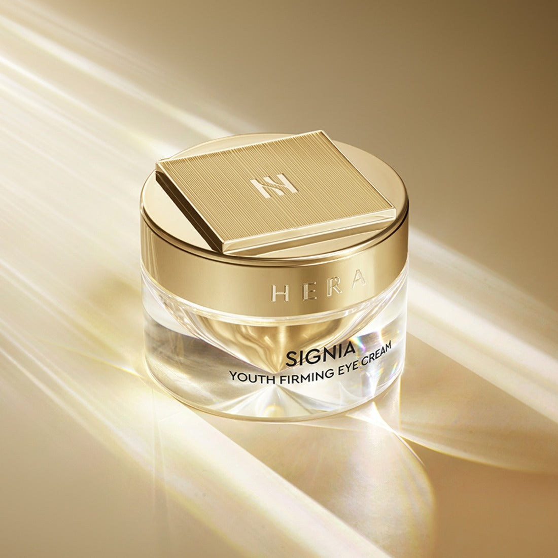 HERA Signa Youth Firming Eye Cream 30ml de HERA, pot crème doré sur fond beige lumineux, photo produit.